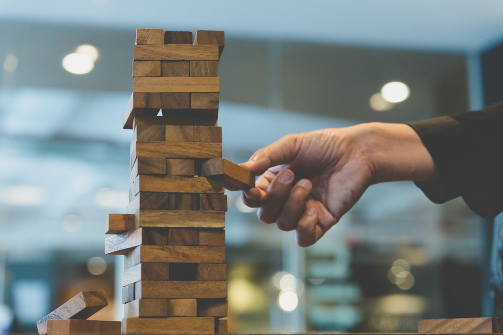 planning, risk and strategy in business, businessman gambling placing wooden block on a tower