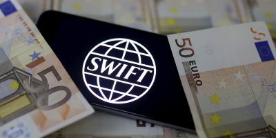 Swift code bank logo is displayed on an iPhone 6s on top of Euro banknotes