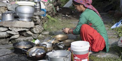 woman cleaning utensils outdoor india