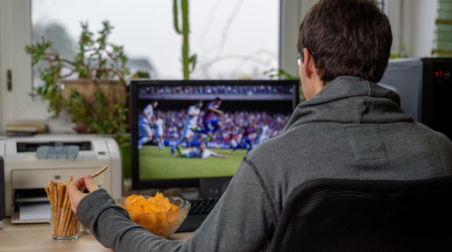 male gamer playing football game on computer