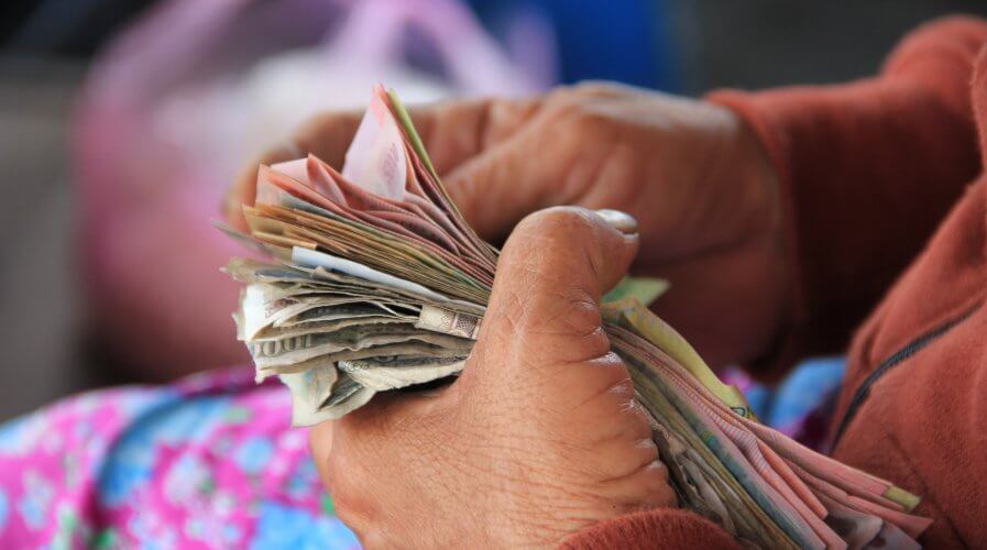 A woman holding and counting a stack of cash