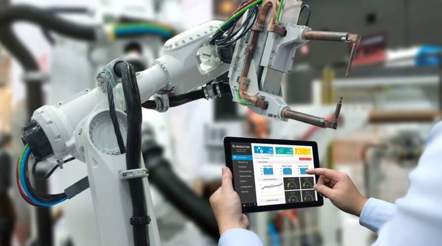 Engineer hand using tablet, heavy automation robot arm machine in smart factory industrial with tablet real time monitoring system application