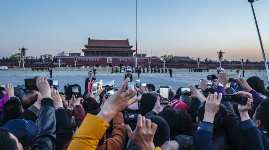 people with mobile phones waiting outside Tiananmen square