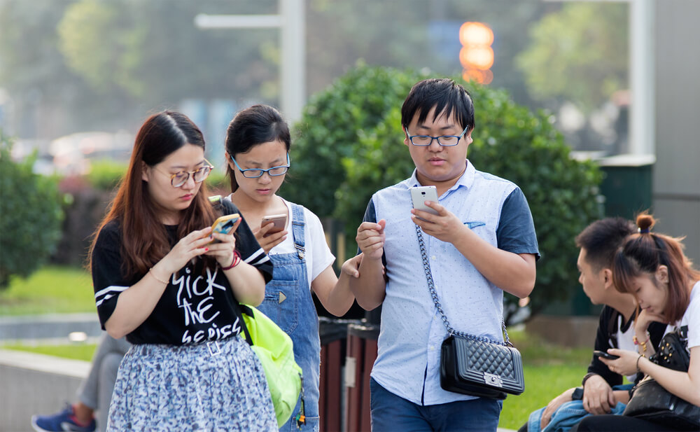 a group of young people looking at their phones