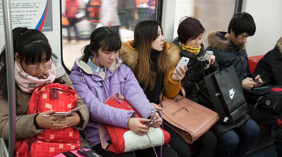 young people using their smartphones while on the train