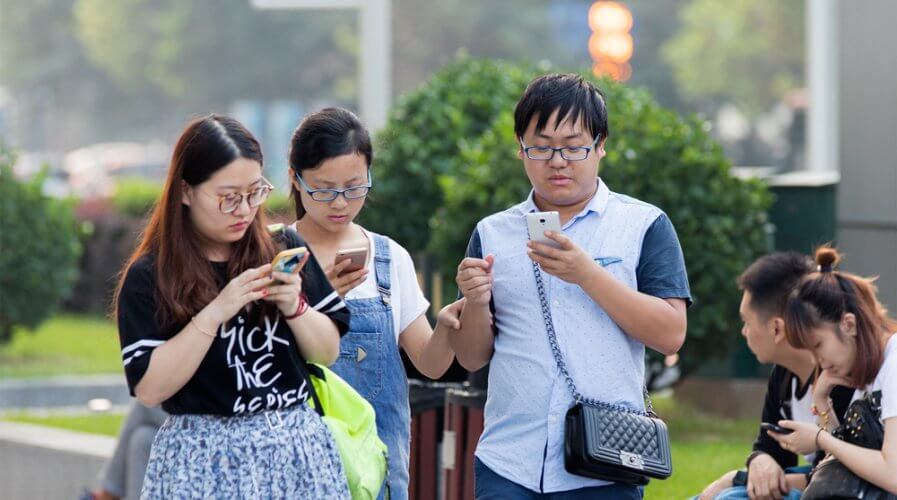 a group of people using their phones in public