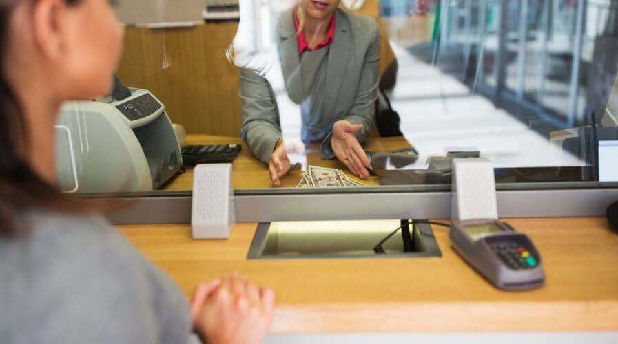 a bank teller helping a customer make payments