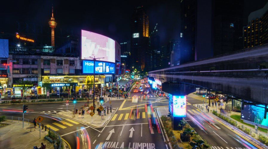 a busy intersection in Malaysia filled with billboards