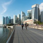 people walking with the backdrop of singapore's financial district
