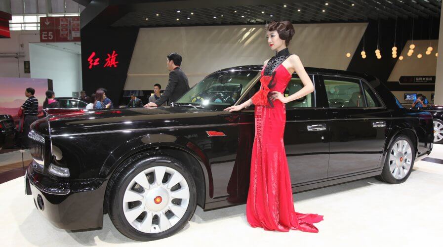 (FIle) Models pose with a Hongqi L5 car on display at the China International Exhibition Center new venue during the "Auto China 2014" Beijing International Automotive Exhibition in Beijing on April 20, 2014. Source: AFP
