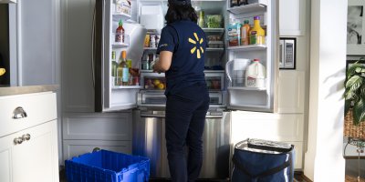 Walmart associate stocking a fridge with InHome Delivery. Source: Walmart