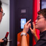 An Alibaba employee helps a customer at a facial recognition check-out booth. Source: AFP.