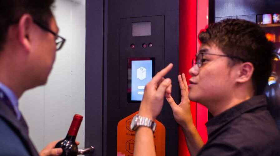 An Alibaba employee helps a customer at a facial recognition check-out booth. Source: AFP.