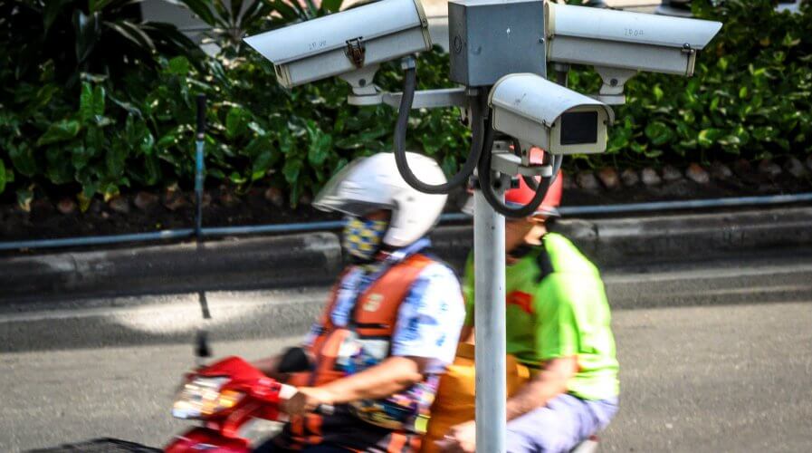 A closed circuit TV (CCTV) system is seen as a motorcycle taxi rider ferries a passenger in Bangkok. Source: AFP