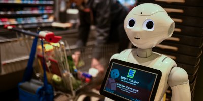 A humanoid robot at the cash desk of a supermarket.