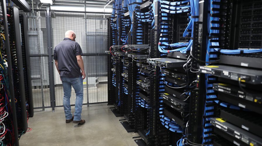 A man works among the racks and switches in a data center. Source: AFP.