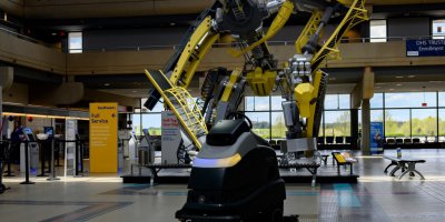 A UV floor cleaning robot cleans the floor near the ticketing windows at Pittsburgh International Airport.