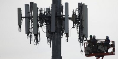 Contractors working on a cell tower to update it to handle 5G in APAC