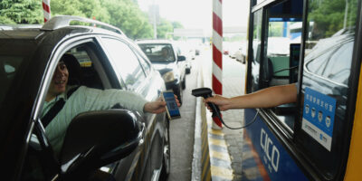 A driver uses his smartphone to pay the highway toll by way of Alipay at Pengbu toll station on the Hangzhou-Ningbo Expressway in Hangzhou