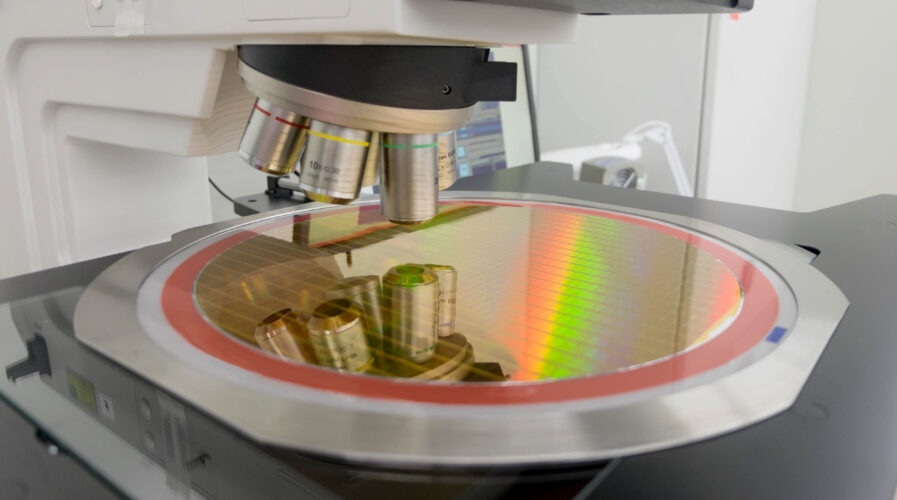 Silicon wafer on machine waiting examining, manufacture in a clean room.