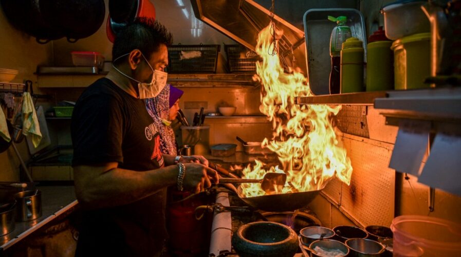 A man cooks a dish in a Kuala Lumpur restaurant -- Easy Eat aims to transform restaurants into 'tech companies' with their disruptive digitization options. (Photo by Mohd RASFAN / AFP)