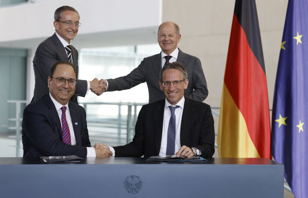 German Chancellor Olaf Scholz (background R) shakes hands with Pat Gelsinger (background L), CEO of US multinational corporation and technology company Intel, as State Secretary at the Chancellery Joerg Kukies (foreground R) and Intel Executive Vice President Keyvan Esfarjani (foreground L) also shake hands after signing an agreement between the German government and Intel on June 19, 2023 at the Chancellery in Berlin. (Photo by Odd ANDERSEN / AFP)