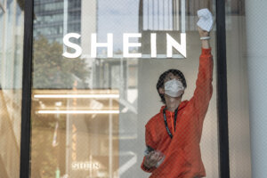 This photo taken on November 10, 2022 shows a man cleaning the windows of the first permanent showroom of Chinese online fast fashion giant Shein, during a media preview in Tokyo. (Photo by Richard A. Brooks / AFP).