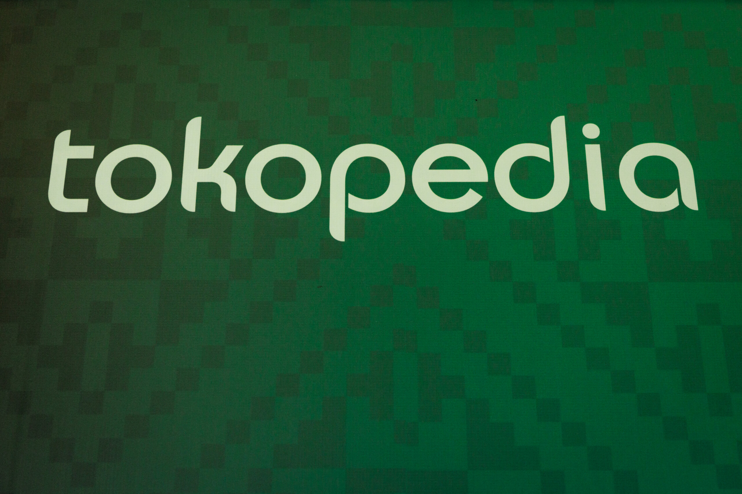 The logo of Indonesia's leading e-commerce site Tokopedia is seen during the launch of the Buy Local Campaign in Jakarta on December 12, 2023. (Photo by Yasuyoshi CHIBA / AFP).