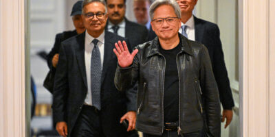 Jensen Huang, co-founder and chief executive officer (CEO) of Nvidia, waves as he arrives for a media roundtable in Kuala Lumpur on December 8, 2023. (Photo by Mohd RASFAN / AFP).