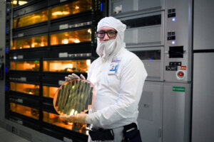 An Intel factory employee holds a wafer with 3D stacked Foveros technology at an Intel fab in Hillsboro, Oregon. (Credit: Intel Corporation).